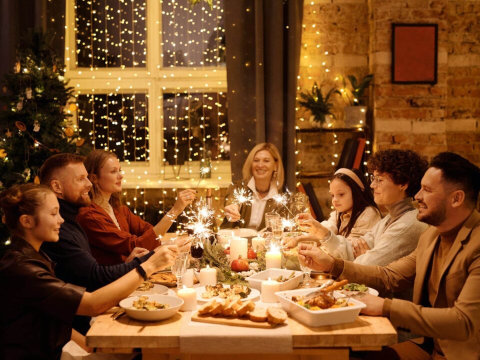 family celebrating christmas while holding burning sparklers